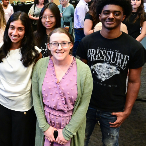 Four smiling people pose for a photo.