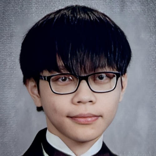 Young person with dark hair and glasses smiles slightly against a textured gray background.
